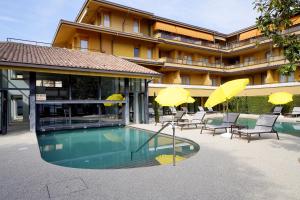 a hotel with a swimming pool with chairs and umbrellas at Hotel Du Lac et Bellevue in Bardolino