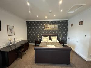 a bedroom with a bed and a desk in it at Basingstoke Hotel in Hook