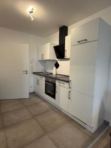 a kitchen with white cabinets and a stove top oven at Smart-Stay Bielefeld in Bielefeld