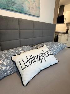 a bed with a pillow with the word leonoreatown at Smart-Stay Bielefeld in Bielefeld +2 photos