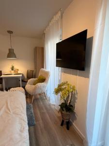 a living room with a flat screen tv on a wall at Smart-Stay Bielefeld in Bielefeld