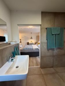 a bathroom with a sink and a bedroom with a bed at Smart-Stay Bielefeld in Bielefeld