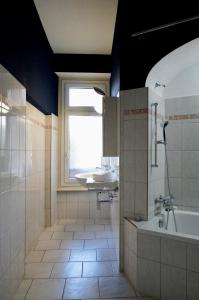 a bathroom with a sink and a tub and a window at ReLiving - Historic City Apartment in Lucerne +17 photos