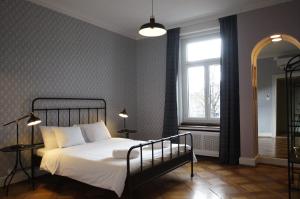 a bedroom with a bed with white sheets and a window at ReLiving - Historic City Apartment in Lucerne