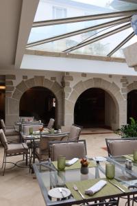 ein Restaurant mit Tischen, Stühlen und Fenstern in der Unterkunft Hotel Suave Mar in Esposende