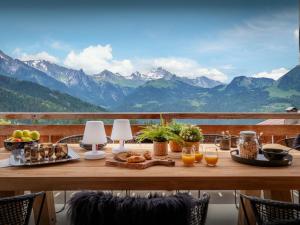 a table with food on it with mountains in the background at Chalet Sivara - OVO Network in Manigod