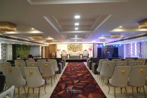 a room with a bunch of chairs and a stage at Red Leaf Hisar in Hisār