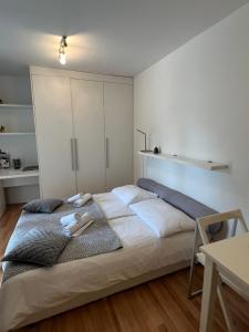 a bedroom with a large bed with white walls at Apartments Annette - studio and two bedroom apartment with parking in Dubrovnik