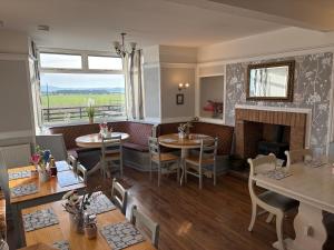 a restaurant with tables and chairs and a fireplace at The Island View B&B - A1 in Berwick-Upon-Tweed
