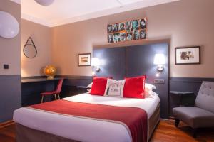 a hotel room with a bed and a chair at Hotel George Sand Opéra Paris in Paris