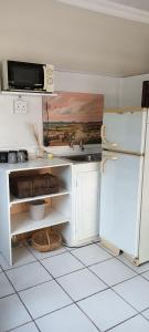 a kitchen with a sink and a refrigerator at Meltz Inn in Klerksdorp +3 photos
