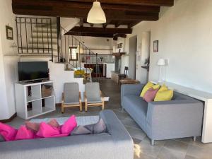 a living room with two couches and a television at Agriturismo Valsiniga - Your Private Family Retreat on Lake Garda Saló in Salò
