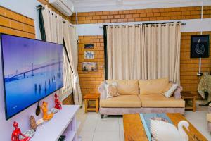 a living room with a couch and a large screen tv at Fern Haven in Port Harcourt