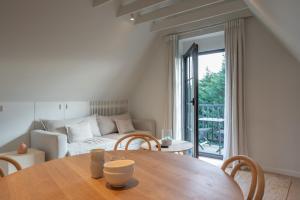 a living room with a table and a couch at Calm, Light-Filled Apartment with Private Balcony in Knokke-Heist