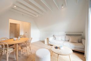a living room with a table and a couch at Calm, Light-Filled Apartment with Private Balcony in Knokke-Heist +6 photos