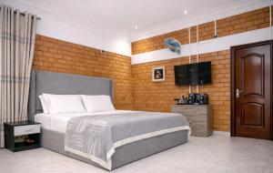 a bedroom with a bed and a flat screen tv at Fern Haven in Port Harcourt