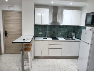 a kitchen with white cabinets and a white refrigerator at Ágora House Alcalá de Guadaira 2 in Alcalá de Guadaira