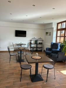 a living room with tables and chairs and a couch at Shubu Zen Vendégház in Szilvásvárad