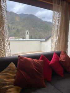 a couch with pillows sitting in front of a window at LHE Terrazza Alba in Bagno di Romagna