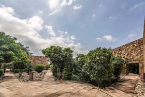a courtyard with trees and a brick building at Mana Ranakpur in Ranakpur
