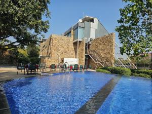 a swimming pool with chairs in front of a building at Mana Ranakpur in Ranakpur