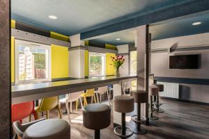 a bar in a restaurant with colorful chairs at Hotel Ibis Budget Fecamp in Fécamp