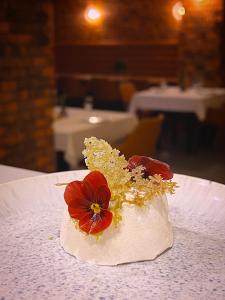 a white dessert with a red flower on a table at Vila Slavonika in Slavonski Brod