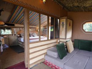 a bedroom with a bed and a couch in a room at Taiga Forest Mountain Tree house in Wayanad +69 photos