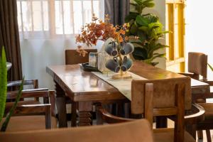 a wooden table with a vase of flowers on it at Urban Escape Apartment in Mbarara