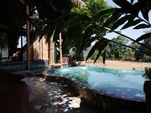 a swimming pool in a resort with a palm tree at Taiga Forest Mountain Tree house in Wayanad