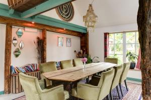 a dining room with a wooden table and chairs at BoHo Experience Wellness, Jacuzzi, Sauna, BBQ, Garden, Sleeps 10 in Kockengen