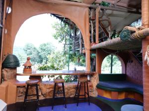 a room with a table and stools in a building at Taiga Forest Mountain Tree house in Wayanad