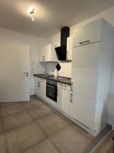 a white kitchen with white cabinets and appliances at Smart-Stay Bielefeld in Bielefeld