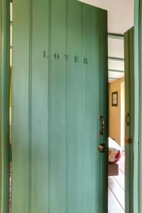 a green cabinet in a room with a door at BoHo Experience Wellness, Jacuzzi, Sauna, BBQ, Garden, Sleeps 10 in Kockengen