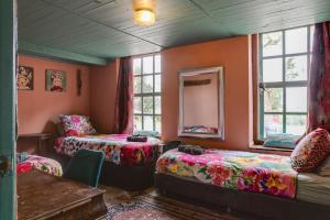 a room with two beds and a table and windows at BoHo Experience Wellness, Jacuzzi, Sauna, BBQ, Garden, Sleeps 10 in Kockengen