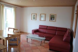 a living room with a red couch and a table at Haus am Mühlberg in Modautal +15 photos