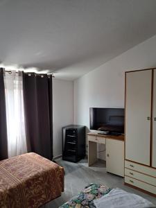 a bedroom with a bed and a desk and a television at Hotel-Ristorante KerMes in Boccaleone