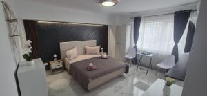 a bedroom with a bed with two pink shoes on it at Little Escape in Brăila