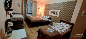 a small hotel room with two beds and a table at K14 Rooms Lublin in Lublin