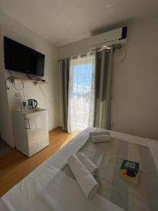 a bedroom with a large bed with a tv on the wall at Villa Ivanovic in Budva