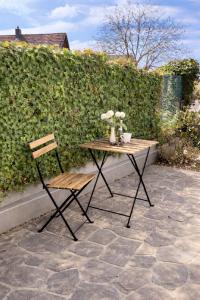 a wooden table with a chair and flowers on a patio at Charmantes Apartment Roding mit 3 Schlafzimmer in Roding +2 photos