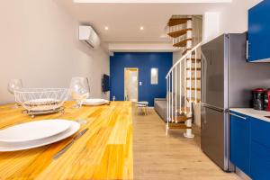 a kitchen and dining room with blue walls and a wooden table at La Maison de lOrb in Valras-Plage +18 photos