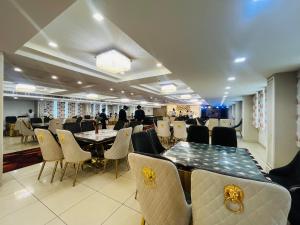 a conference room with tables and chairs and people in the background at Red Leaf Hisar in Hisār