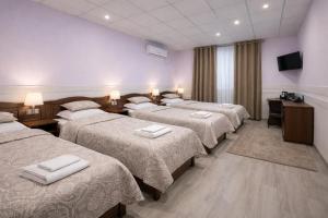 a group of four beds in a hotel room at Hotel Sofia Samarkand in Samarkand
