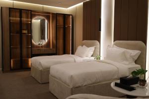 a hotel room with two beds and a mirror at ضيافة ألسعادة للشقق ألمخدومة - قرطبة1 in Riyadh