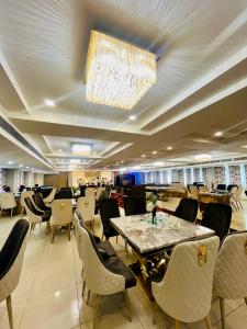 a restaurant with a table and chairs and a chandelier at Red Leaf Hisar in Hisār