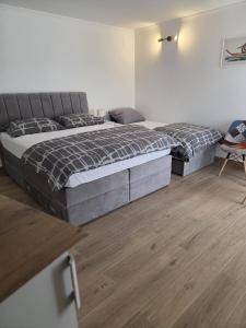 a bedroom with two beds and a wooden floor at Guesthouse Ivan in Skradin