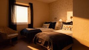 a hotel room with two beds and a window at Arctic Panorama Lodge in Uløybukta