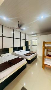 a bedroom with two beds and a ceiling at Hotel GANANJAYA in Gokarna