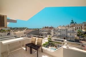 a balcony with a white table and chairs and buildings at Side Orientt Apartments in Side